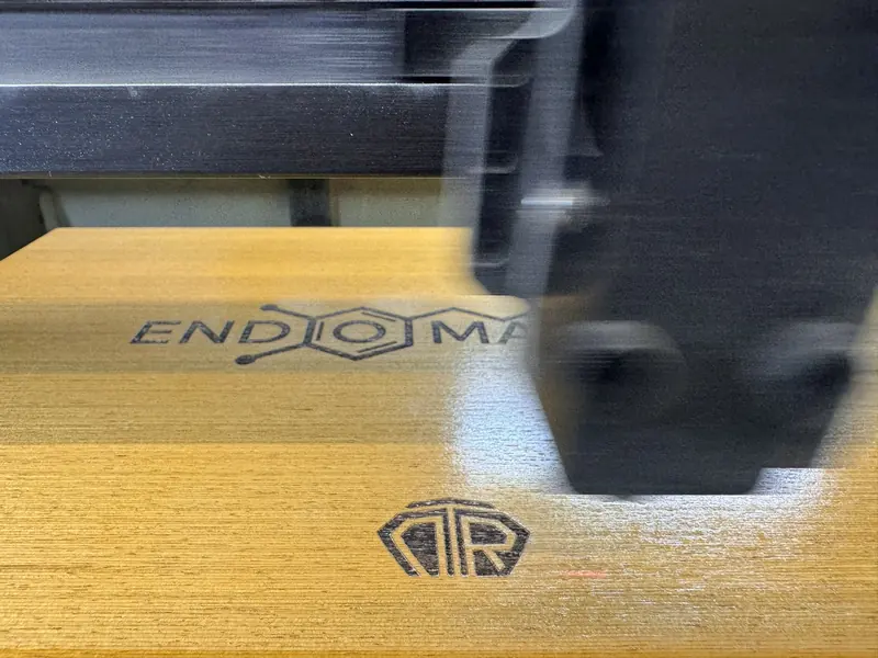 Firmenlogo wird mit dem CO2-Laser auf eine Holzkiste graviert