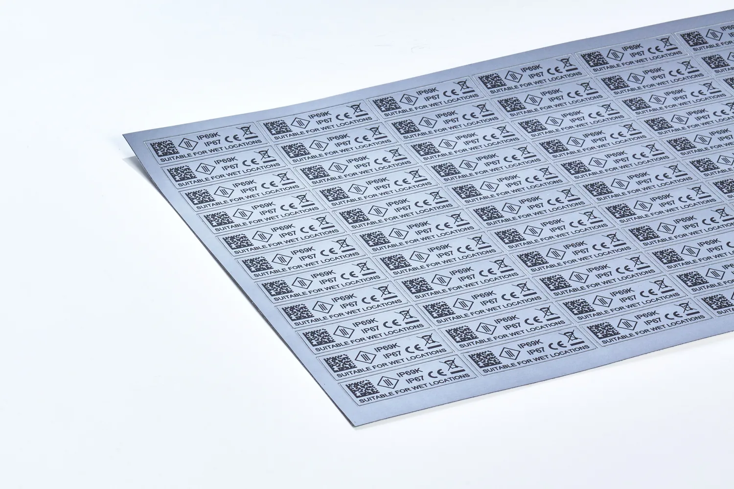 Bogen mit hunderten Laseretiketten, jedes mit DataMatrix-Code und Schutzartangabe