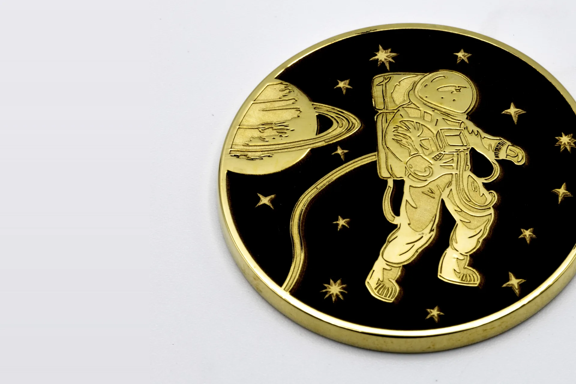 Tiefengravierte Messingmünze mit Astronautenmotiv und geschwärztem Grund